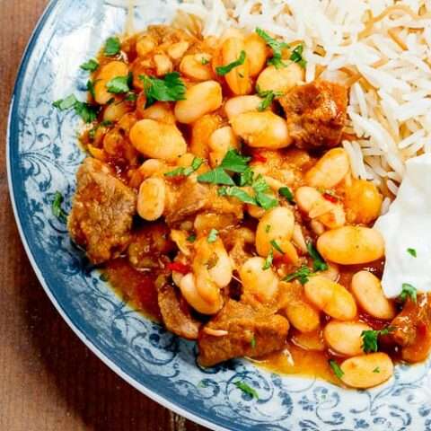 خورش لوبیا سفید ترکی با برنج و ماست در بشقاب آبی طرح دار که از بالا دیده می شود خورش لوبیا سفید ترکی با برنج و ماست در بشقاب آبی طرح دار که از بالا دیده می شود